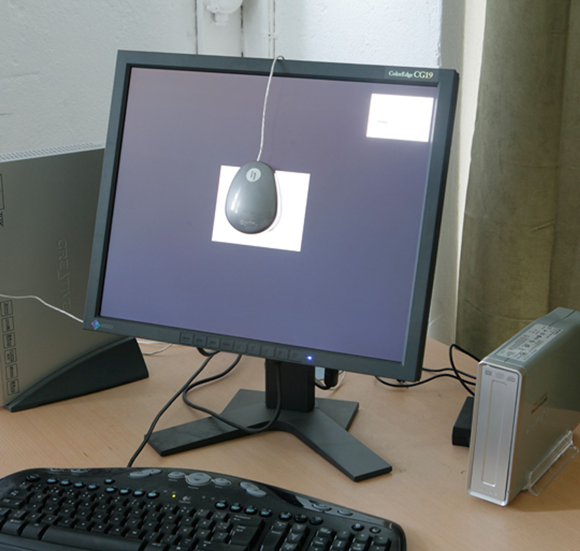 Eksempel p&aring; oppsett for kalibrering av skjerm. Kolorimeteret, i dette tilfellet ColorMunki, ligger an mot skjermen, slik at det kan "se" hva skjermen viser.