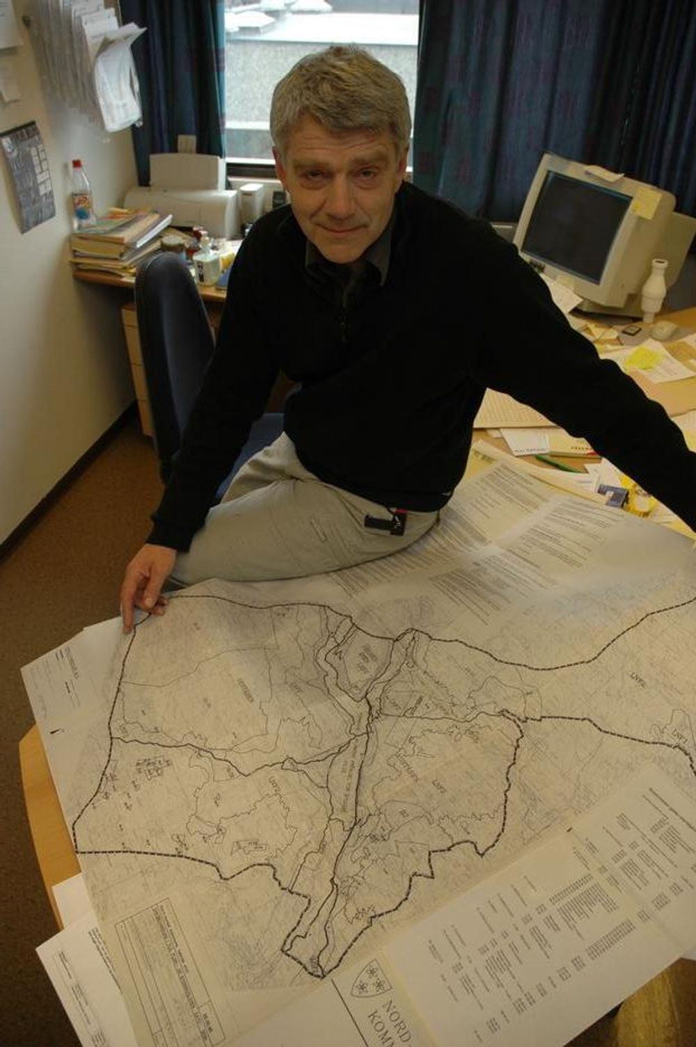 Tjenesteleder og virksomhetsansvarlig Erik Endrerud bretter ut kartet og forteller om kommunens 80 km veger.