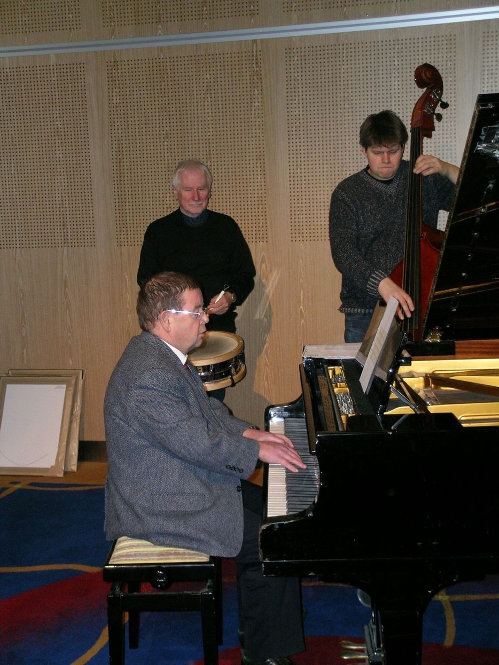 Trioen Jazzfalt med konferanseleder Helge Aalefjær ved flygelet innledet Asfaltdagen 2006. Erik Wego på trommer og Erik Strandberg på bass.