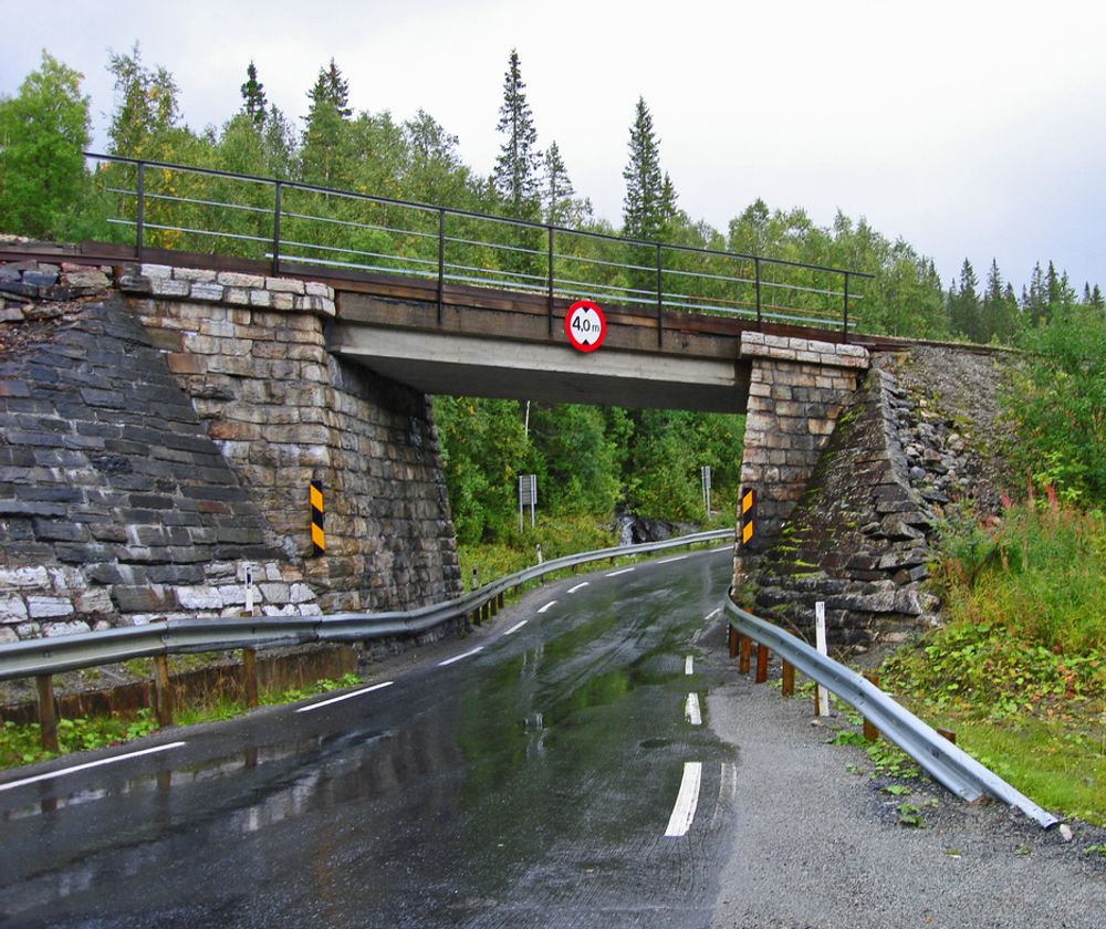 Denne trange undergangen under Nordlandsbanen ved Skogtun i Grane kommune hører ikke hjemme på en europaveg. Som skiltet viser, er den frie høyden 4 meter. Bredden er bare 4,5 meter. Høsten 2010 inngår den ikke lenger i E 6. (Foto: Anne-Lise Sæther, Statens vegvesen)