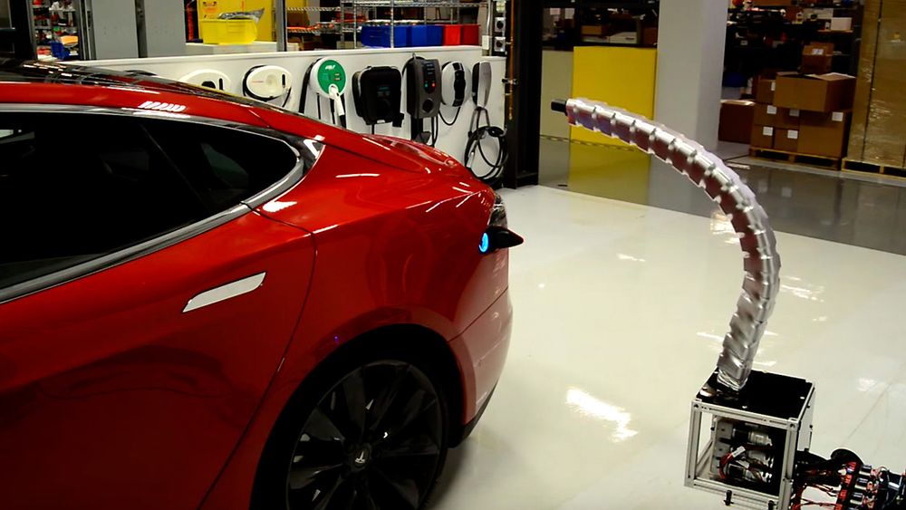 Tesla viser frem en ladeplugg som finner veien til ladeporten på egen hånd. 