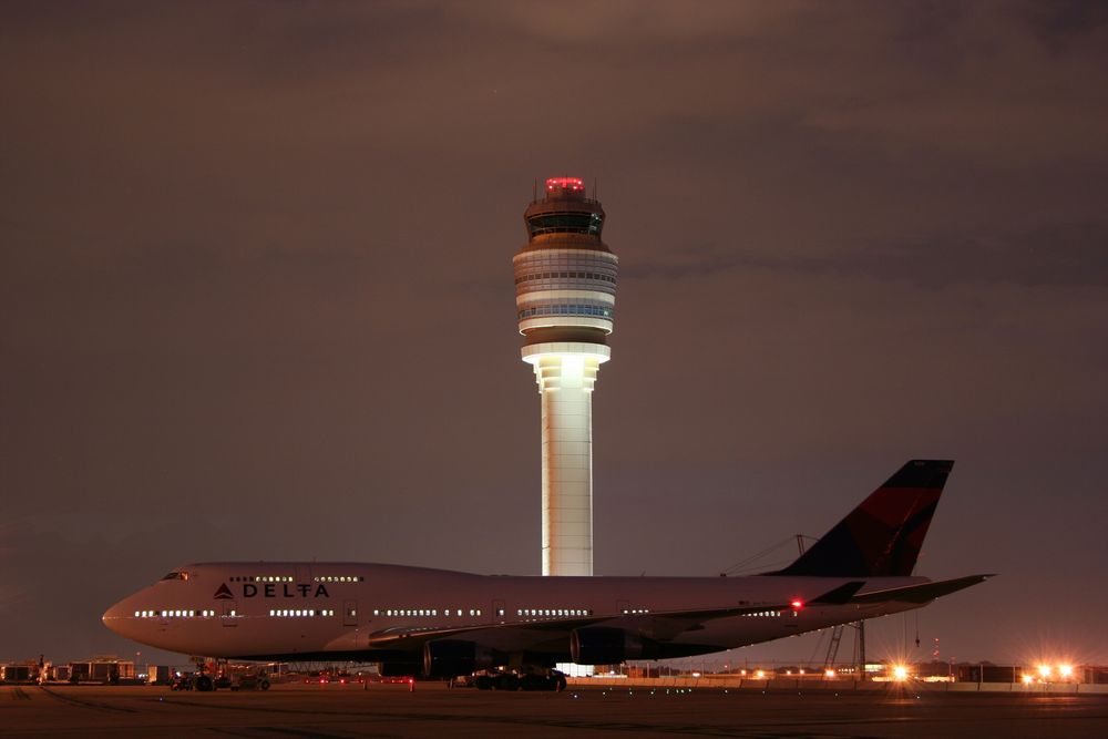 En Boeing 747-400 fra Delta Air Lines på Hartsfield-Jackson Atlanta lufthavn. Fra ATL kan 80 prosent av den amerikanske befolkningen fly hjem på under to timer. Tårnet er med sine 121 meter det høyeste i Nord-Amerika og det fjerde høyeste i verden. 