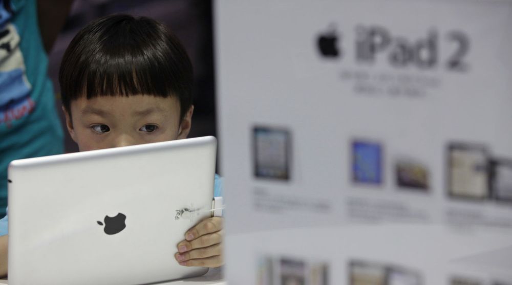 En kinesisk gutt ser på Apples iPad i en butikk i byen Wuhan. Selv om iPad ikke er offisielt til salgs i Kina er etterspørselen og interessen på det grå markedet stor.
