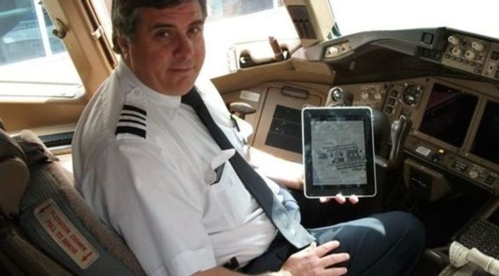 Denne piloten viser fornøyd fram sin iPad, som han i motsetning til passasjerene sine ikke må skru av under avgang og landing.