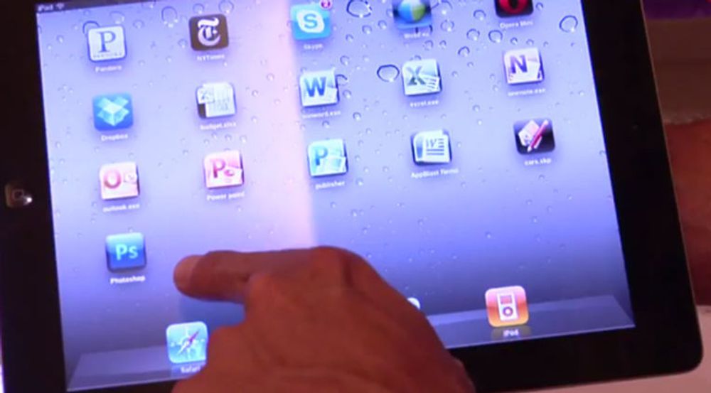 AppBlast gir direkte tilgang til Windows-applikasjoner på en iPad. Her er ikoner for Office-programmer som Word, Outlook og Excel. Merk også ikonet ved pekefingeren: PS for Adobe Photoshop.