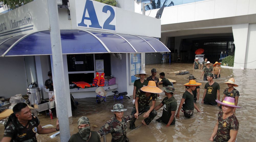 Full stans: Soldater holder vakt ved Western Digitals produksjonsanlegg for harddisker i Thailand, som nå står under vann og er evakuert.