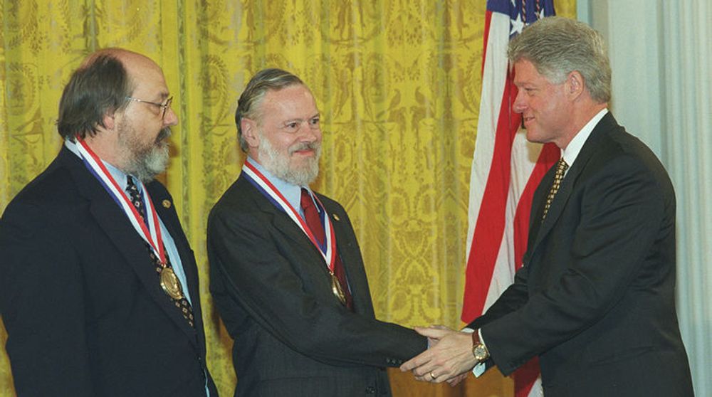 Ken Thompson (til venstre) og Dennis Ritchie (i midten) mottar National Medal of Technology fra president Bill Clinton i 1999.