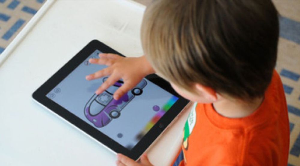 En ung skoleelev er opptatt med fargelegging (eller er det fargelære?) på i iPad. Nå strømmer paddene inn i norsk skole, viser tall fra tilrettelegger. 