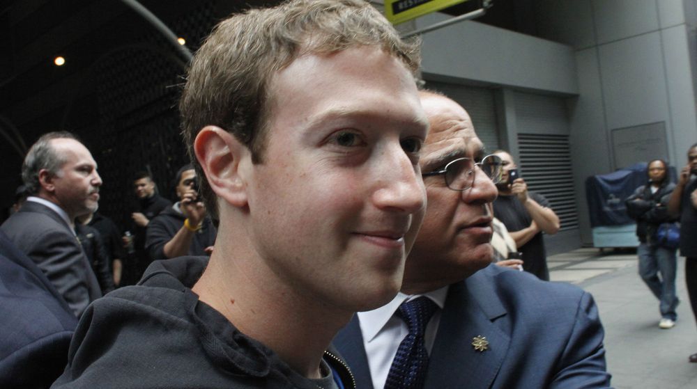 Mark Zuckerberg blir geleidet av sikkerhetsvakter på vei til et møte med mulige investorer i New York mandag. En av tingene investorer nok er bekymret for er den voldsomme bruken av Facebook via mobilen. Den er nemlig langt fra så lønnsom som bruk via PC. 