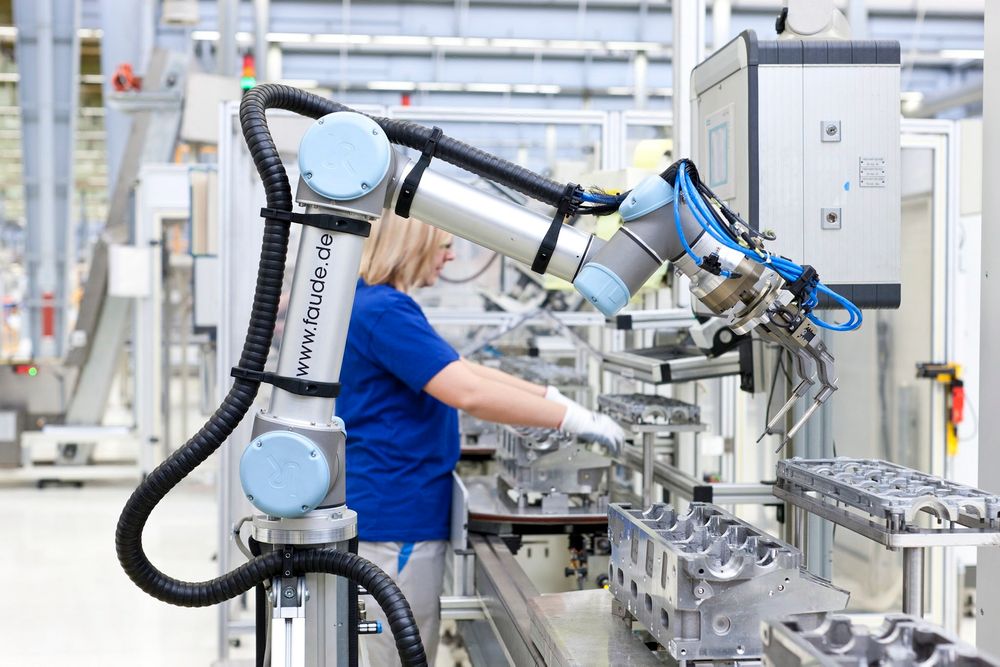 Robot og menneske samarbeider om å sette inn glødeplugger i bilmotorer hos Volkswagen.