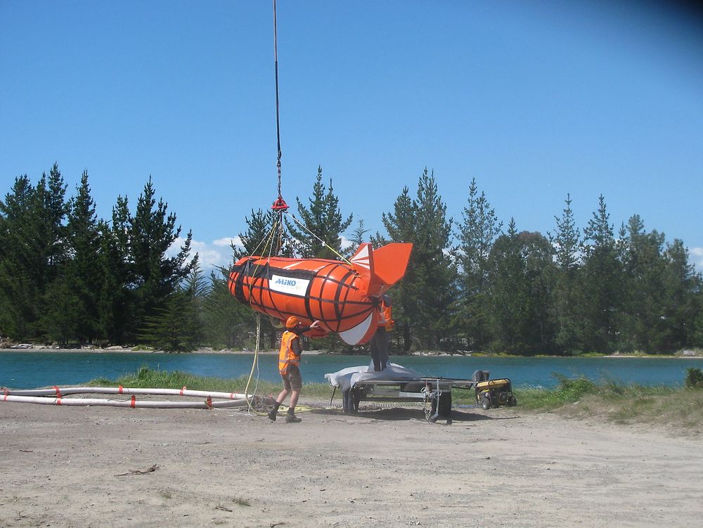 Helikopter henter Ship Arrestor. Kjettingen ligger inne i den oppblåste ringen til venstre. Drivanker, bøye og "pick up"-utstyr for tauing ligger inne i plastbagen. Finnene sørger for at bagen er lett å ha hengende under helikopteret.           
