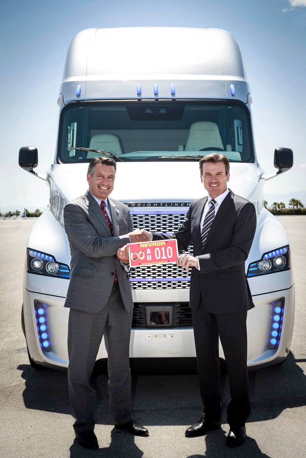 Nevada-guvernør Brian Sandoval (t.v) var på plass for å skru på et skilt som markerer at Freightliner Inspiration er verdens første autonome lastebil som kan kjøre på vanlige veier. Daimler-topp Wolfgang Bernhard til høyre.