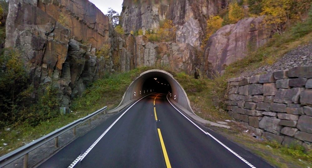Dette er søndre portal i Logatunnelen på E39 nord for Flekkefjord. De som vil ha ansvar for drift og vedlikehold av den og 27 andre tunneler i Vest-Agder, må gi anbud innen 18. februar. (Foto: Google)