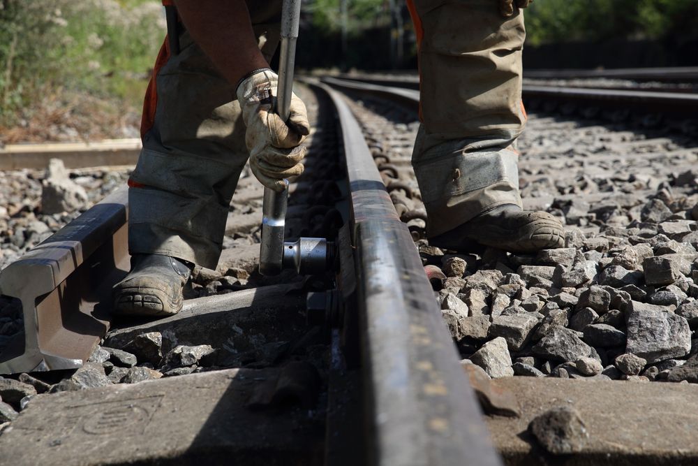 Micael Anderson fra Norsk Jernbanedrift fester bolten på de nylagte skinnene på Østfoldbanen på Loenga. Sporene ble revet i forbindelse med bygging av en ny bru over den kommende byggegropa til Follobanen.
