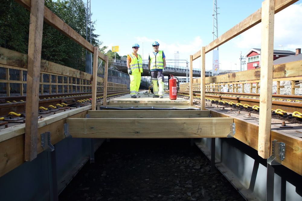 Overordnet byggeleder Anne Marie Syvertsen og byggeleder Kjell Bjarne Lillekvam i Jernbaneverket står på den høyst nødvendige brua over den kommende byggegropa til Follobanen.