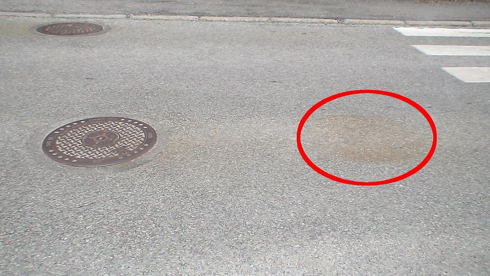 Flere brune flekker oppstår på veien etter kumlokk. Kan du forklare hvordan fenomenet oppstår?