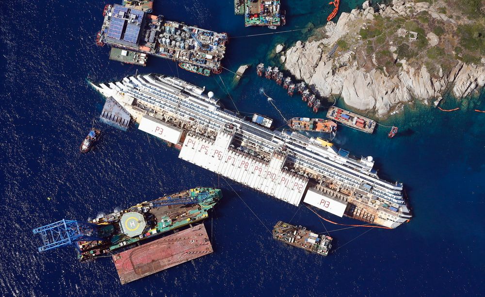 Dette flyfotoet viser Costa Concordia utenfor øya Giglio, og er tatt 26. august i år. 17. september ble skipet rettet opp igjen fra slagsiden. Det skjedde etter over ett års forberedelser. FOTO: REUTERS 