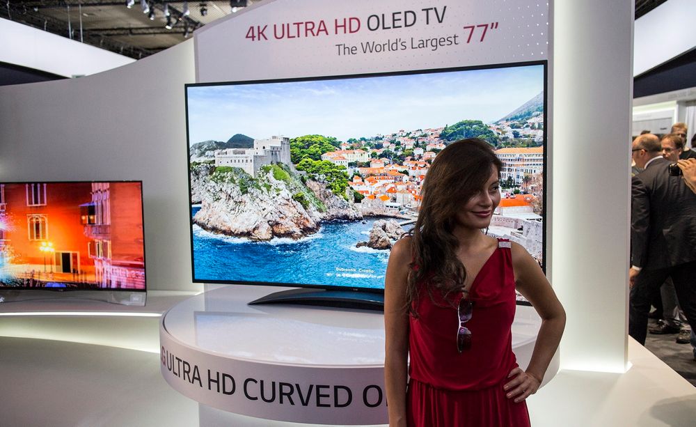 Verdens største OLED: LG overrasket alle og trakk sløret av verdens største OLED-TV. 77 tommer med kurvet skjerm og 4K-oppløsning. Selvfølgelig med smilende vertinne. 