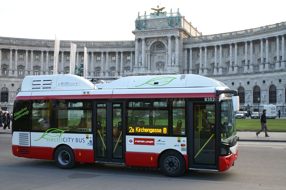 Elektrisk i Wien: I Wien har de hatt 12 små elbusser siden i fjor høst som denne foran Hofburgpalasset. De opererer som en del av det vanlige kollektivtransportnettet. I sommer skal to av rutene kjøres helt elektrisk. 