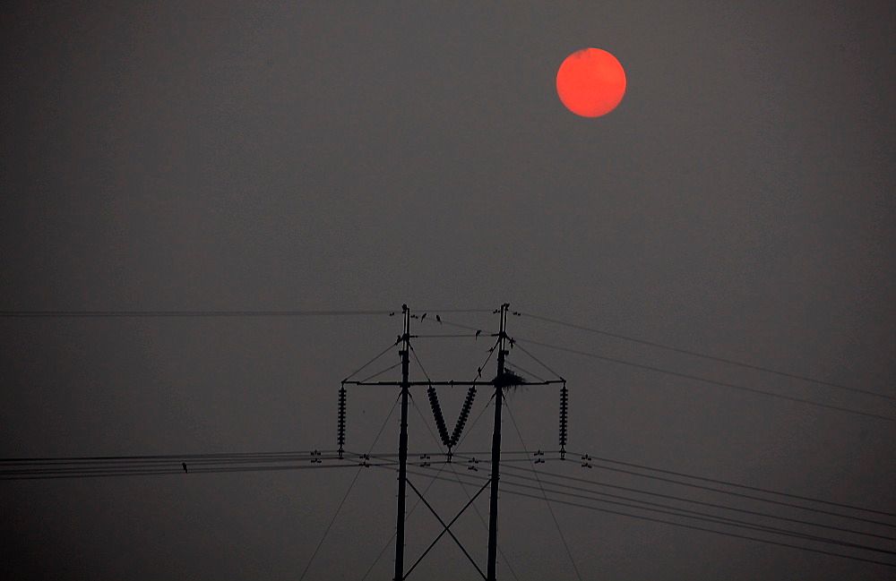 SLIPPER UT MER: Sola står opp og skinner gjennom tykk smog over Beijing. En ny rapport viser at Kinas utslipp av karbondioksid er på linje med utslippene fra EU. Kinas utslipp fortsetter å vokse og økte med 9 prosent i 2011. 