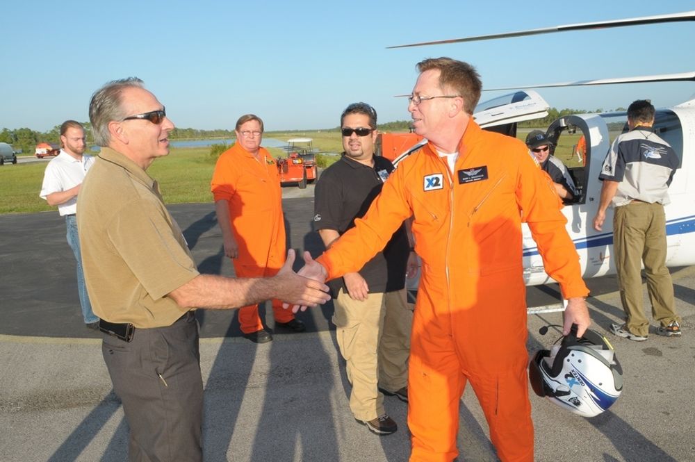Prøveflyger Kevin Bredenbeck får en velfortjent gratulasjon av Sikorsky-sjef Jeffrey Pino (t.v.) etter 250-knopsflygingen med X2.