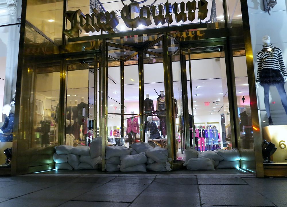NÅDELØST: Selv fasjonable butikker på 5th Avenue tyr til sandsekker for å stenge Sandy ute.    
