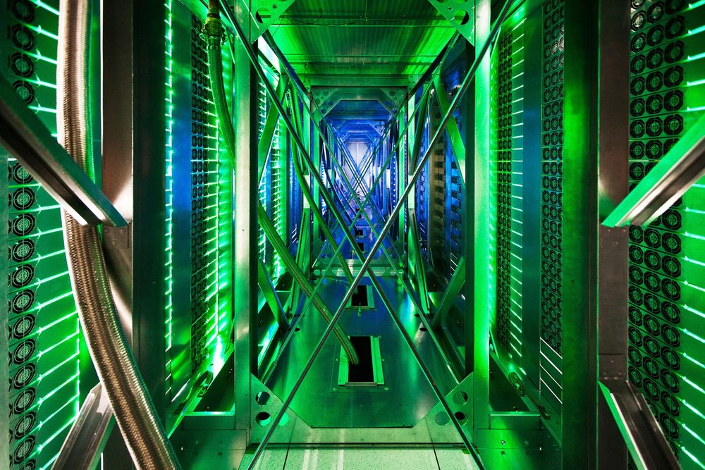 Slik ser det ut bak serverne. Det grønne lyset er refleks fra LED-lysene som varsler om servernes status. 
