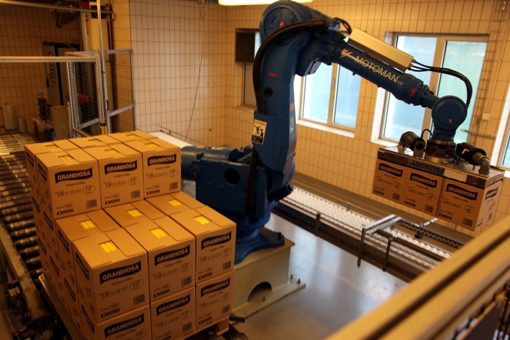 AUTOMATISK: Roboter er blitt viktige i produksjonen av pizza i Stranda. Her stables kasser med nyprodusert pizza, klar for fryselageret og transport til kundene.