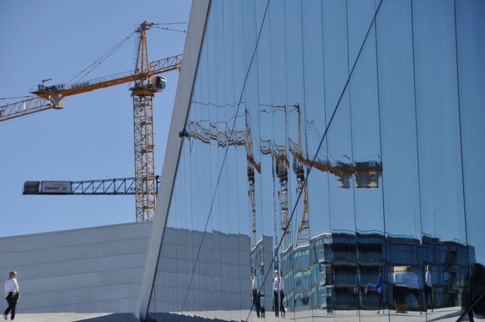 Område i utvikling. Kraner speiler seg i Operaen.