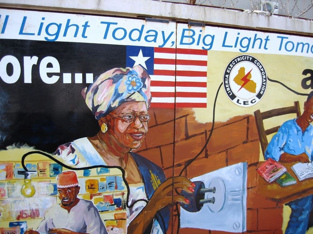 TAKKNEMLIG FREDSPRISVINNER: Liberias president Ellen Johnsen Sirleaf kan på en diger plakat fornøyd sette inn stikkontakten og takke blant andre Multiconsult for at landet får strøm.