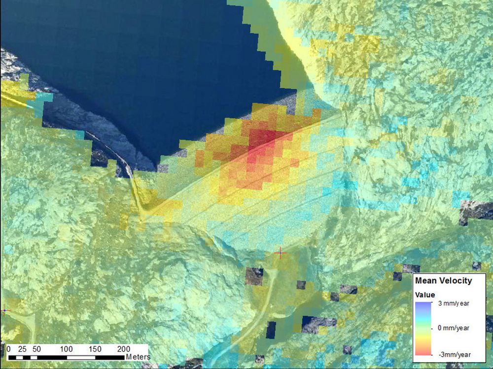 SATELLITTBILDER: Fargekodet deformasjonshastighet ved Sira-Kvinas Svartevassdammen, beregnet fra 23 radarbilder fra perioden 1992-2000. Bildene er tatt med radarinstrumenter på European Remote Sensing-satellittene (ERS-1 og 2) Det røde området langs toppen av demningen indikerer et område med setninger opptil 3 mm/år. Måleusikkerheten ved denne metoden er rundt 1 mm/år, så områder i grønt, lys gult og turkis er områder uten statistisk signifikant bevegelse. Bildene stammer fra et mindre forskningsprosjekt i samarbeid mellom Norut og NGI.