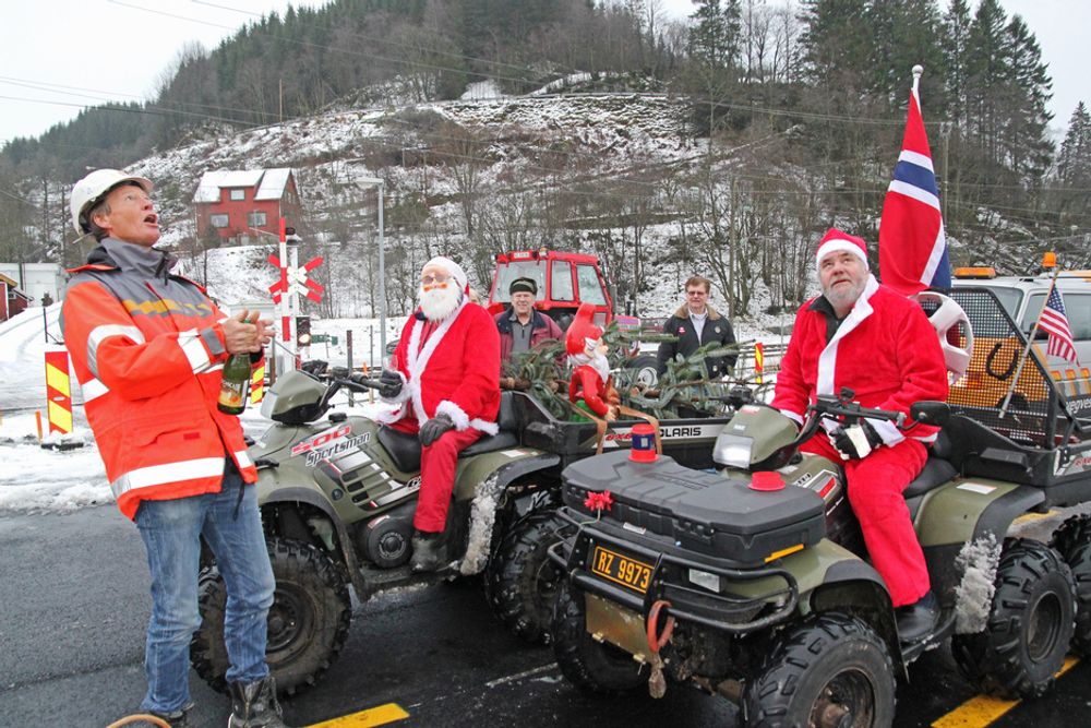 To julenisser markerte at den nye vegen mellom Helleland og Skjebadalen er ferdig. Mannen til venstre som ser langt etter korken, er prosjektleder Tor Oskar Walskaar i Statens vegvesen.