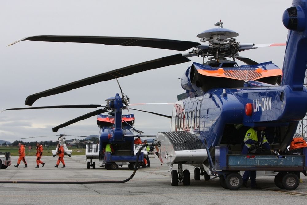 NYTT SKIFT: Et vanlig syn på den hektiske helikopterbasen på Sola: Drivstoff og bagasje er på vei inn i en S-92A-maskin, mens 18-19 offshoreansatte er på vei ut av en annen.