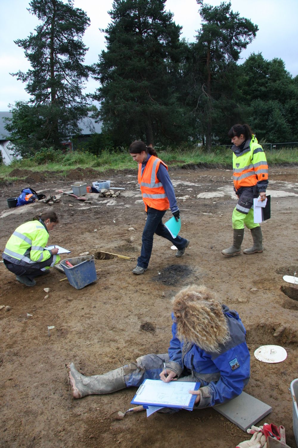 Maria-Liisa Grue (foran) og Lene Melheim graver fram halve stolpehull. Det tas prøver av resten fro å tidfelste funn.