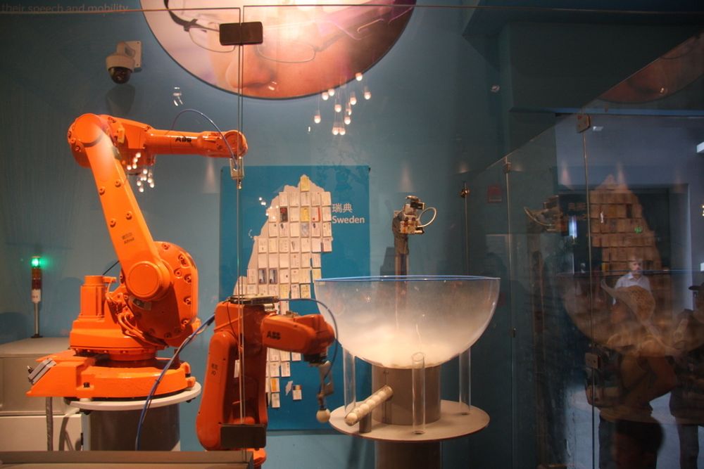 ROBOT: I den svenske paviljongen var dette en populær innretning: En robot som kunne ta imot visittkortet ditt og gi deg en bordtennisball i bytte. Visittkortene ble pent satt opp på veggen. Foto: Tormod Haugstad