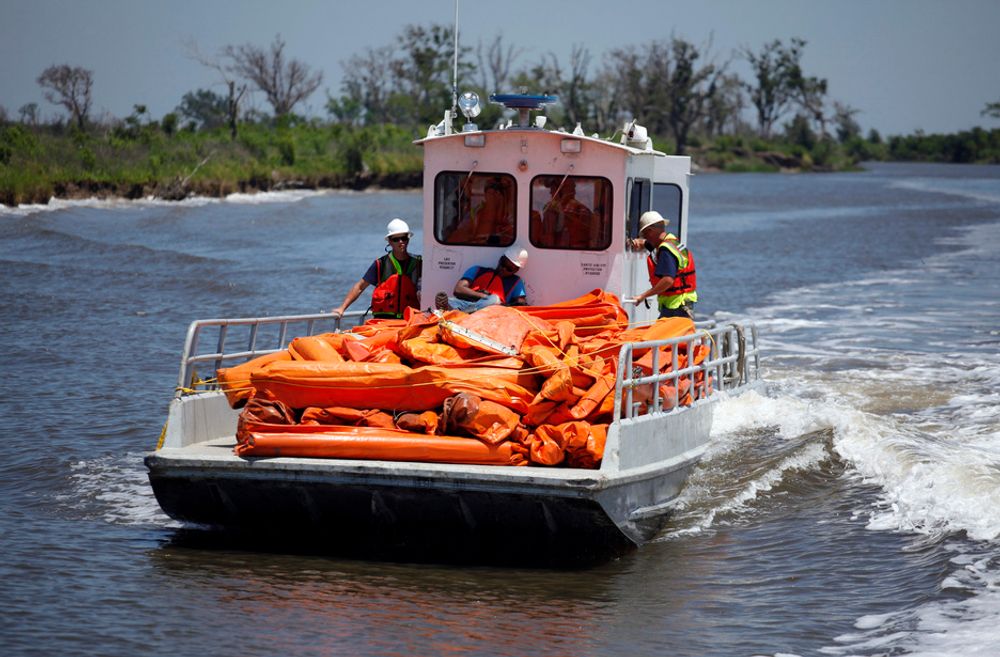 En båt på vei til å legge lenser for å hindre oljesøl i å nå land i Louisiana. Oljekatastrofen kan nå sette bom for klimaloven siden den inkluderer mer leting etter olje utenfor USAs kyster.