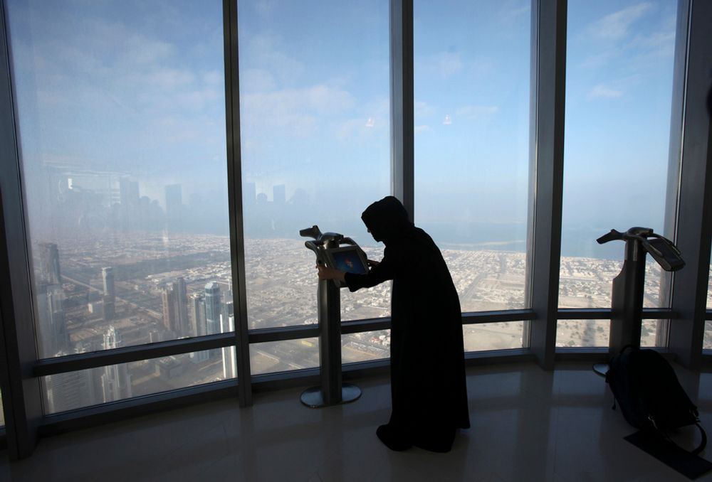 UTSIKT: En kvinne ser utover Dubai gjennom en av kikkertene i utsiktsetasjen (124. etasje) i Burj Dubai-tårnet.