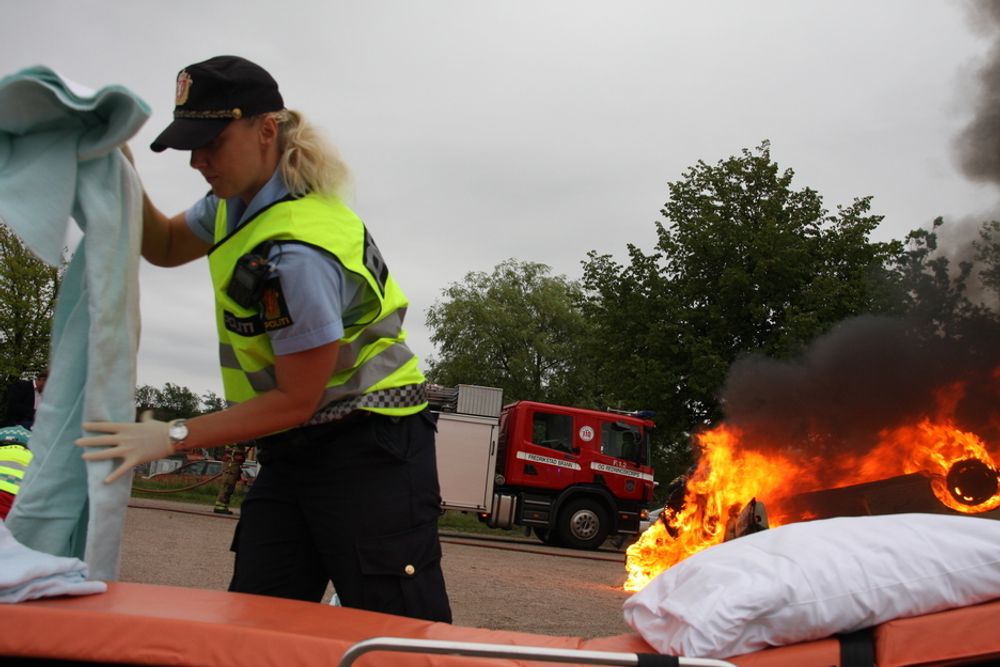BISTÅR: En polititjenestekvinne bistår ambulansepersonellet.