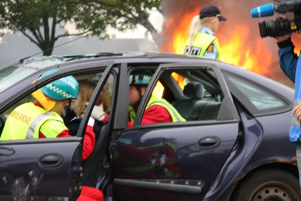 FAST: Mens flammene slikker opp rundt den ene bilen, får en fastklemt fører hjelp i det andre kjøretøyet.