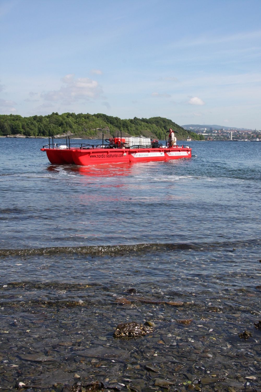 TRE I ETT: En moderbåt med motor skyver to utstyrsprammer. Prammer med pumpe og tanker kan etterlates på strender som skal renskes. Moderbåten brukes i mellomtiden til andre oppdrag og henter etterpå prammene med olje.