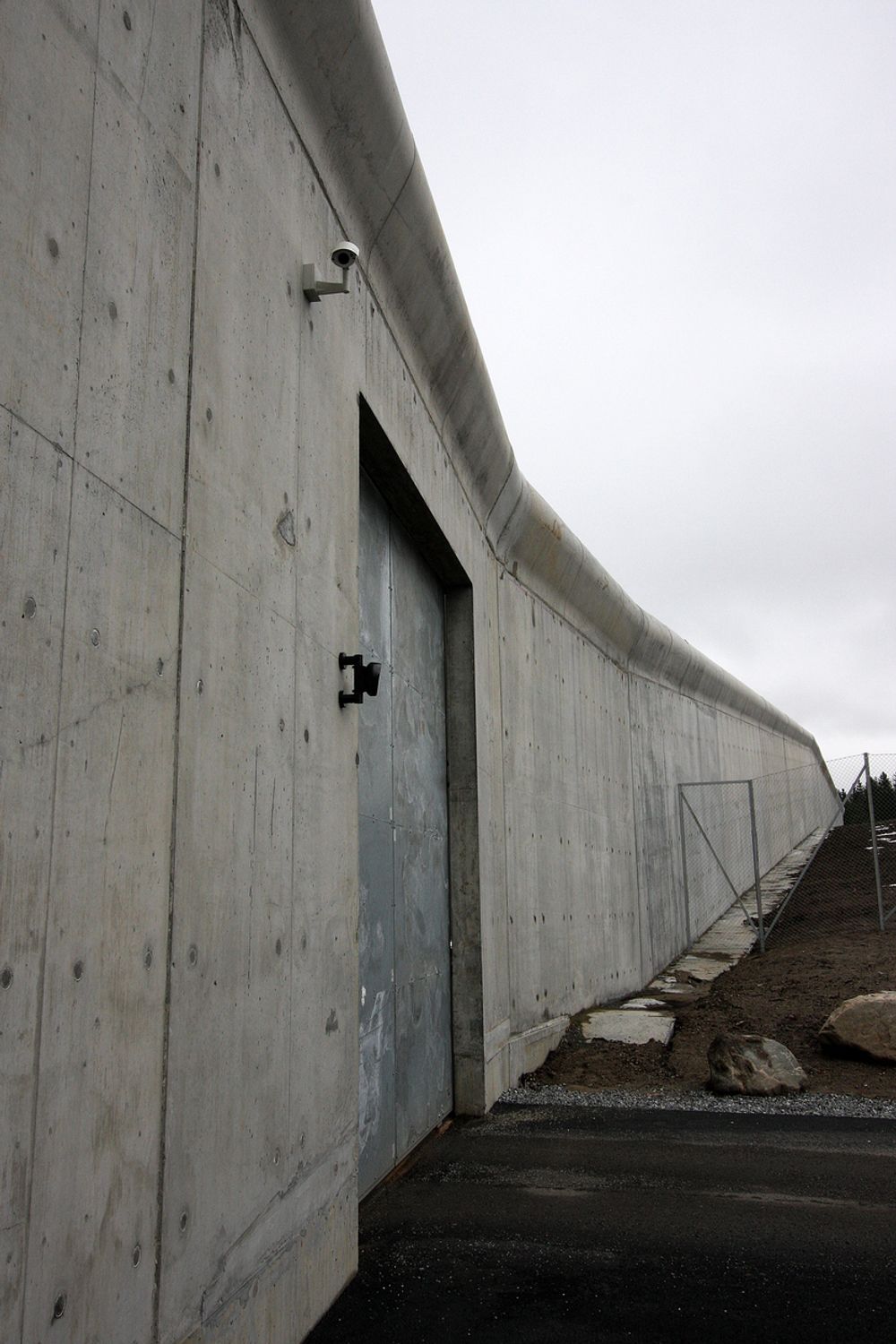 HØY: Fengselsmuren er seks meter høy og 1,3 kilometer lang. Mesta brukte 3500 kubikk ferdigbetong for støpe muren, som står på en 2,5 meter bred betongsåle. Dråpeformen på toppen skal gjøre det umulig å hekte fast rømningsutstyr.