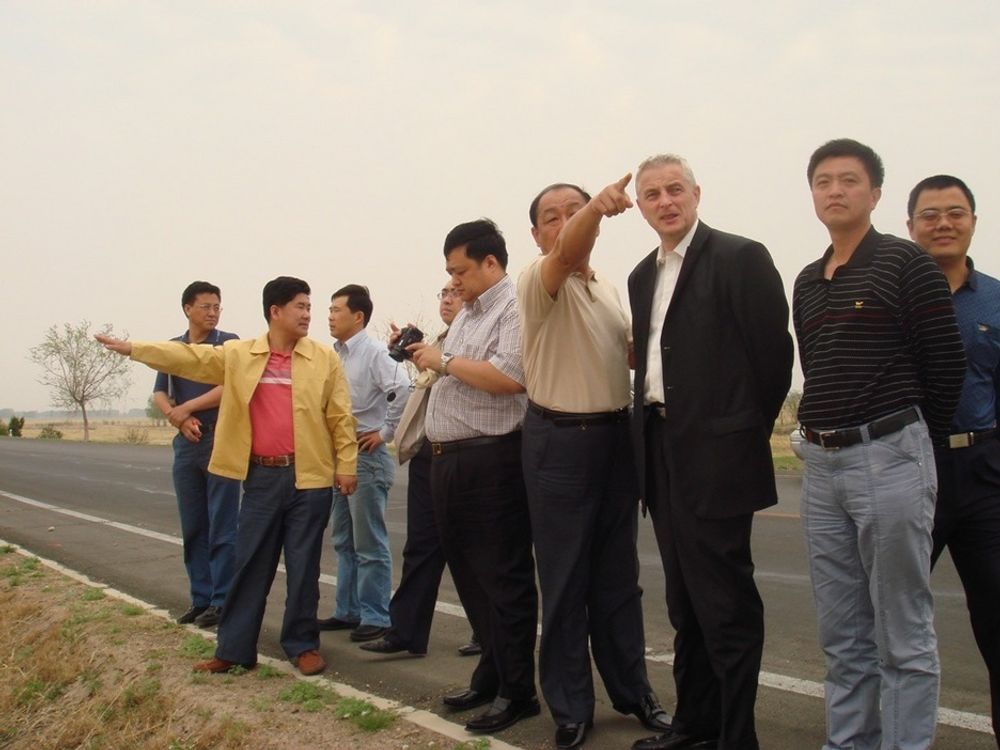 Administrerende direktør Joar Viken i gründerfirmaet NBT AS sammen med sine kinesiske samarbeidspartnere på siten i Baicheng i Jilin-provinsen, hvor selskapets første vindkraftverk skal bygges. Det kinesiske firmaet fungerer som NBTs lokale tilrettelegger, myndighetskontakt og som lokal representant.