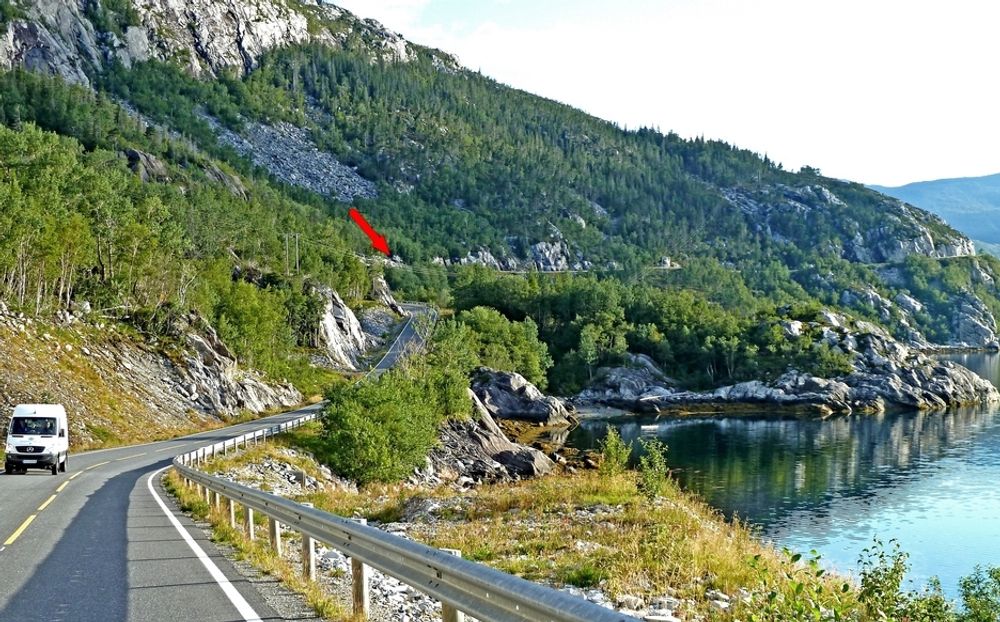 Den røde pilen markerer tunnelinnslaget i sørvest. Vegen langs fjellsiden i bakgrunnen blir stengt når tunnelen åpnes 12.12.1012.