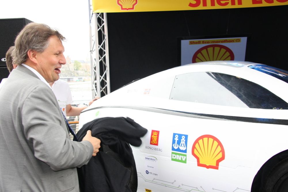 AVDUKER: Olje- og energiminister Terje Riis-Johansen avduker NTNUs bil DNV Fuel Fighter, en av to norske deltagere i Shell Eco-marathon, et billøp for energigjerrige biler. NTNU håper å nå 1000 km på energi tilsvarende en liter bensin.