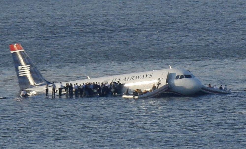 Passasjerene har kommet seg ut av flyet og står på vingene og venter på å bli reddet.