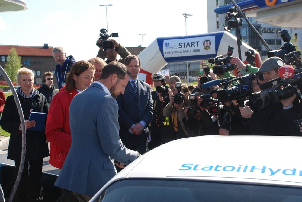 FYLLER: Kronprins Haakon fyller hydrogentanken på en Mazda RX-8 hydrogenbil. I bakgrunnen Einar Håndlykken i Zero og Statoils Alexandra Bech Gjørv.