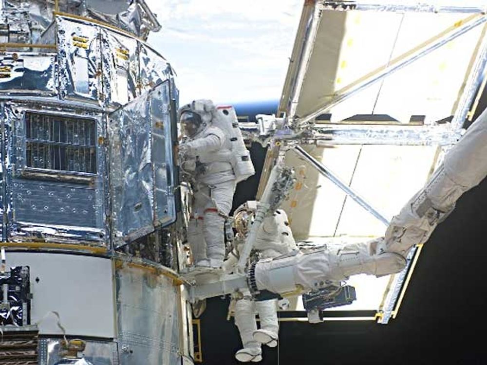 Astronauts John Grunsfeld (left) and Richard Linnehan work to replace the Hubble Space Telescope's power control unit during the last Hubble servicing mission in March 2002. Courtesy NASA.