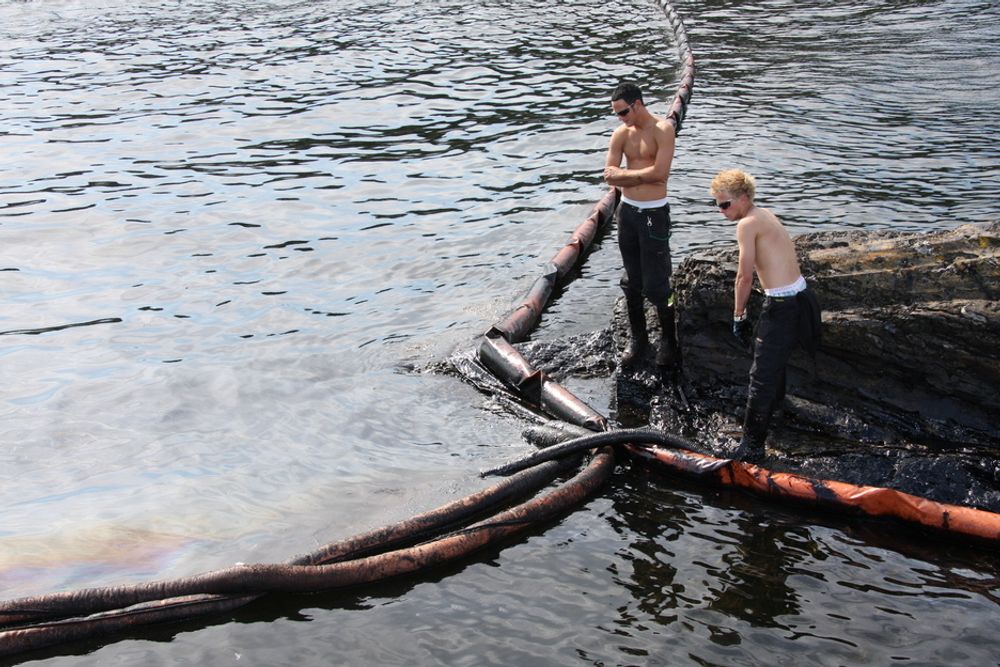 Mannskap fra Veolia Miljø suger opp olje i Krogshavn ved Langesund.