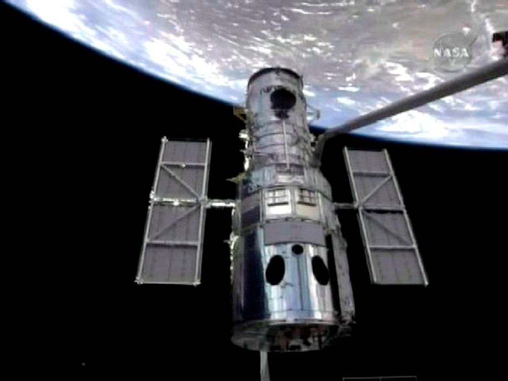 Robotarmen på romferja Atlantis grep onsdag om romteleskopet Hubble og trakk det med inn i romferjas lasterom for en omfattende overhaling.