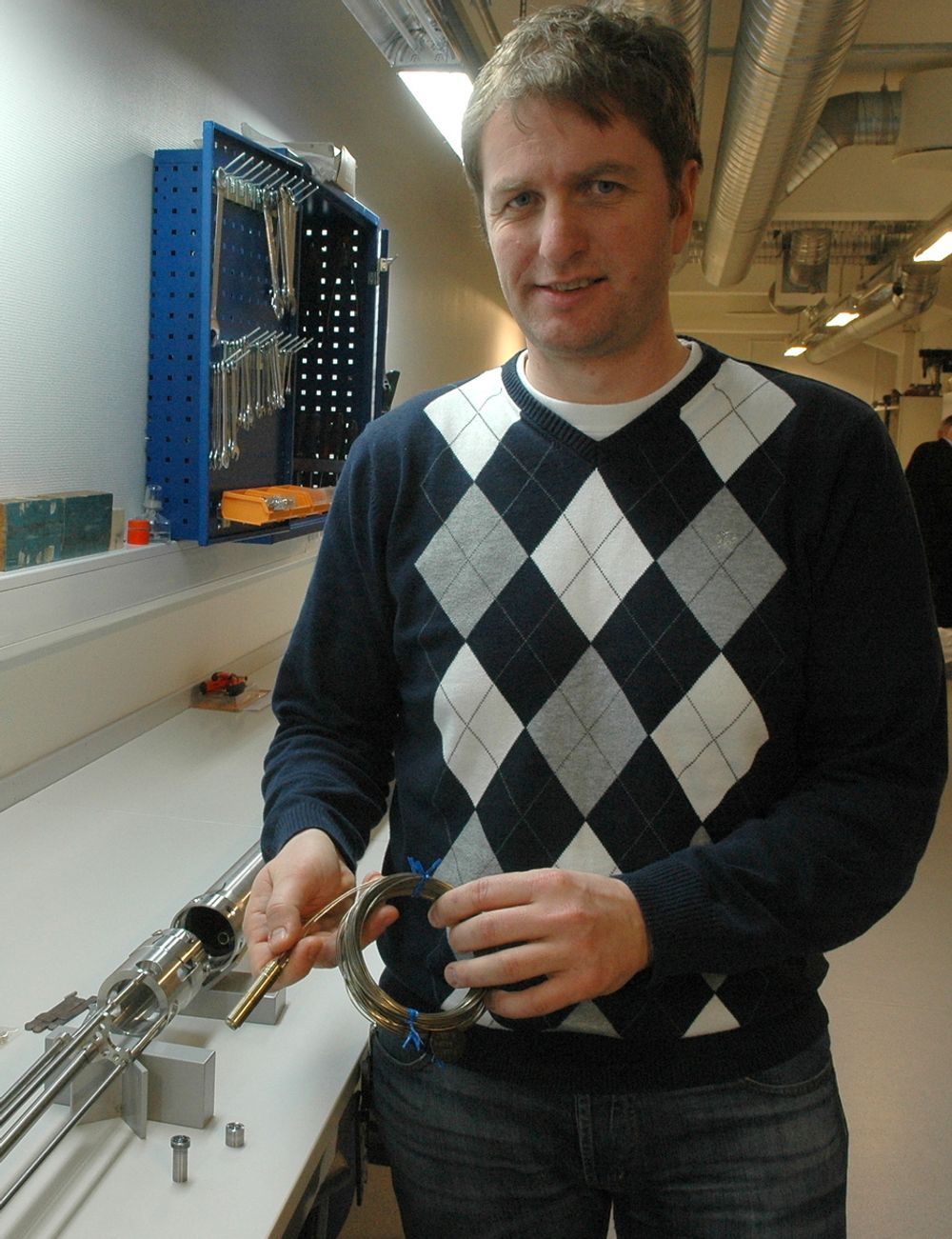 LAGER TESTRIGG: Knut W. Eriksen med en testrigg for instrumentering i reaktorkjernen. Maksimal diameter for hele oppsettet er 73 millimeter.